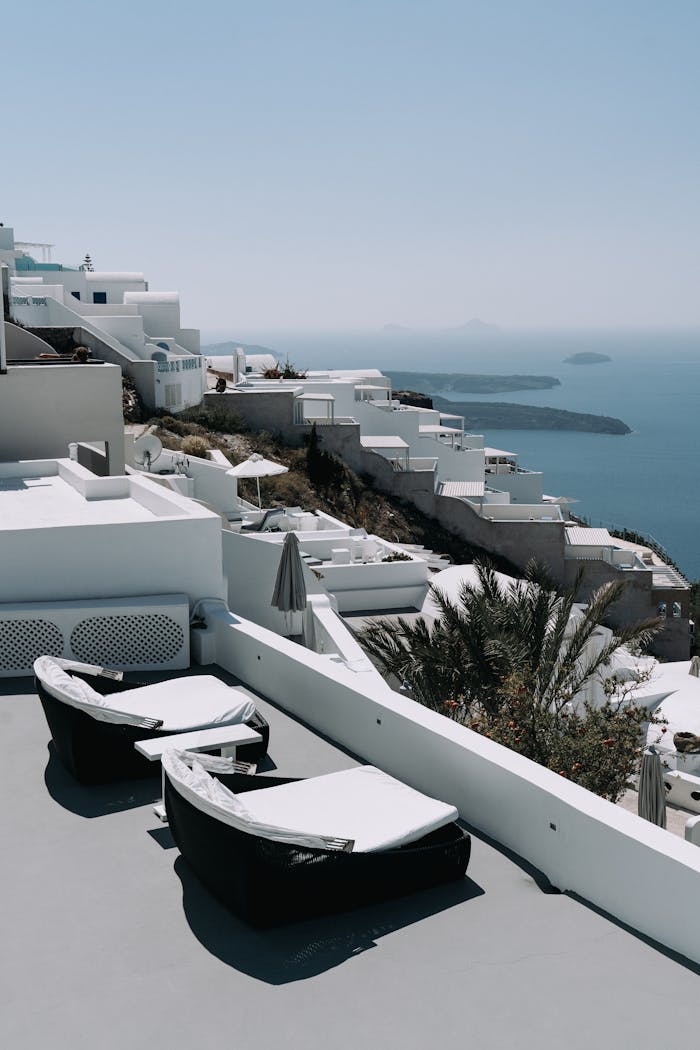Luxurious terrace overlooking Santorini's iconic white buildings and deep blue sea.