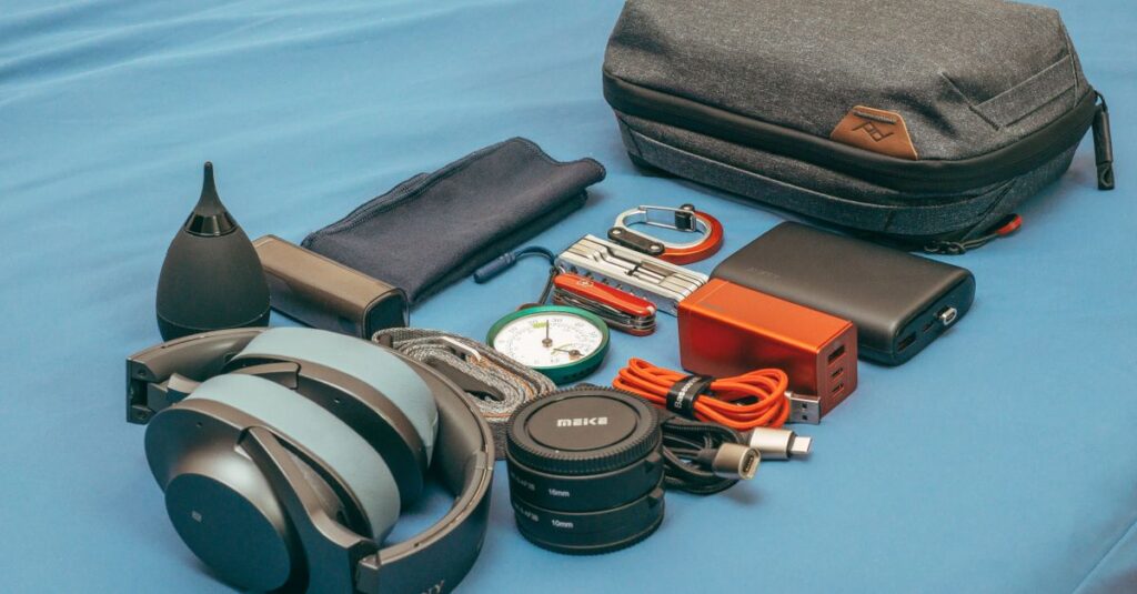 pexels photo 6088772 6088772 Flat lay of travel gear including headphones, a compass, power bank, and accessories.