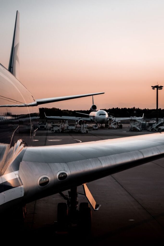 Two airplanes parked on a tarmac during sunset, showing airport operations.