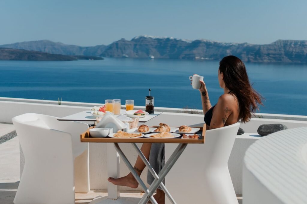 pexels photo 28077098 28077098 Enjoy a relaxing breakfast by the sea with a stunning view of Santorini's caldera.